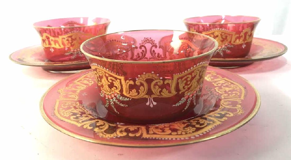 Lot 6 Red & Gold Toned Bohemian Glass Set: Lot includes 3 plates & 3 bowls. Each piece has intricate ornate gold toned detail. Pieces are glass and cranberry toned. Plates measure approx 7 inches wide. tableware, decorative accessories, shelf 