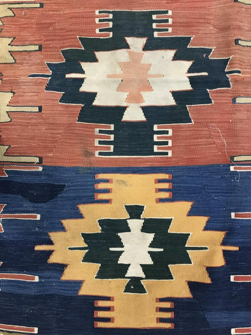 Antique Handmade Native American Style Wool Rug: Rug is handmade appears to be antique. Contains tones of red, beige, coral, blue & green. Contains braided & non braided fringes. Measures approx 68 inches long 46 inches wide. Contains some holes. Ho