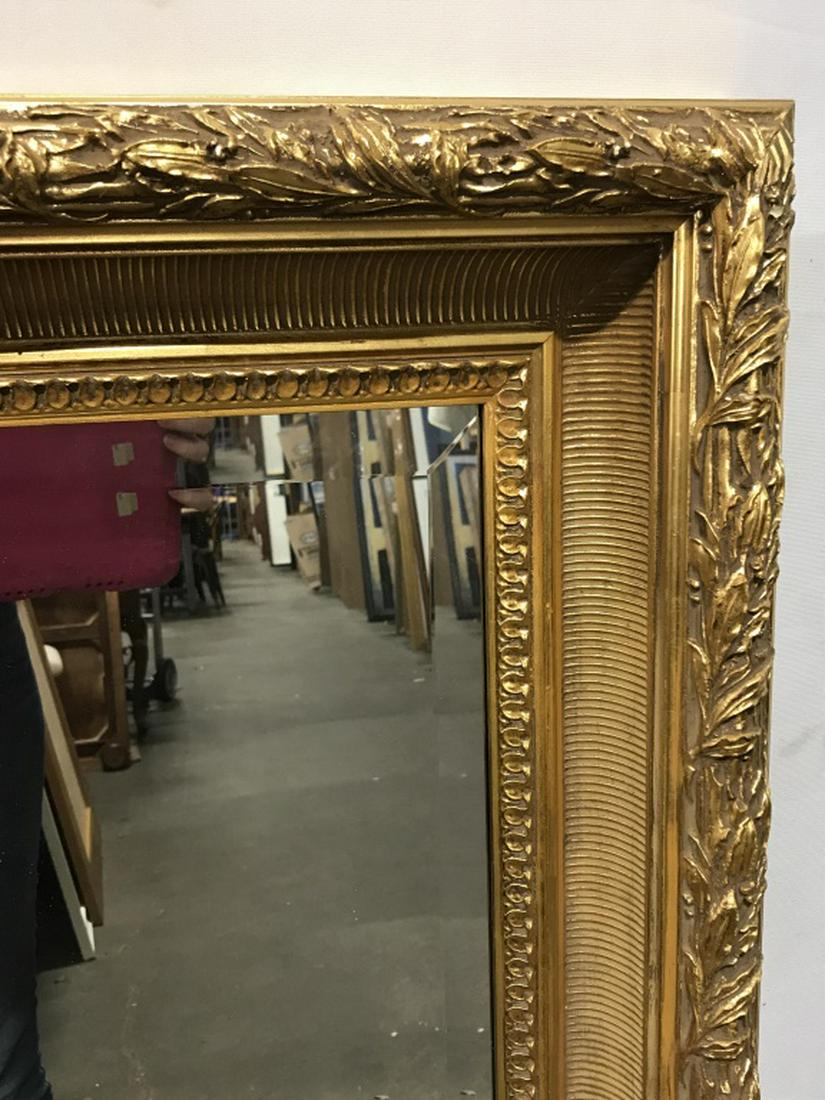 Oversized LaBarge Beveled Mantel Mirror: La Barge beveled Mantel mirror in gold tone wood frame with ribbed texture and leaf pattern relief border trim. Marked on verso for LaBarge. Measures approx 48.5 inches by 38.5 inches in length and wi