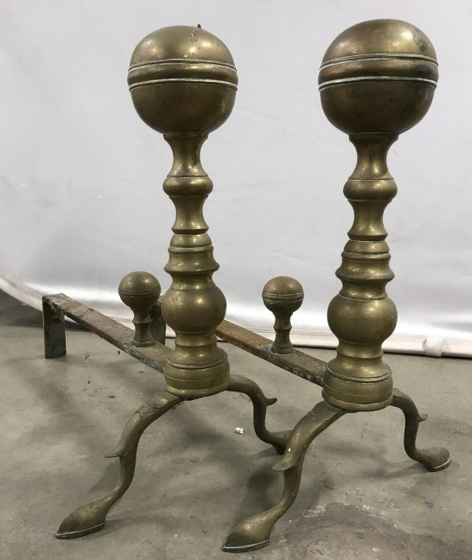 Lot 4 Andirons in Brass & Wrought Iron: Lot 4 andirons includes 2 pairs, each with brass fronts and wrought iron racks. One andiron is missing part of its back. The taller pair measures approx 16.5 inches in height by 11 inches in width by 