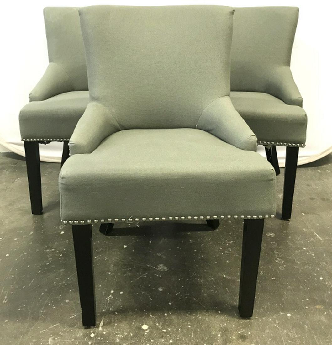 Lot 3 Upholstered Dining Chairs: Chairs are gray-green in tone. Silver tone tack details. Undersides are marked for SAFAVIEH. Chairs have some surface wear, including blemishes. Might need spot cleaning and restoring of undersides. E