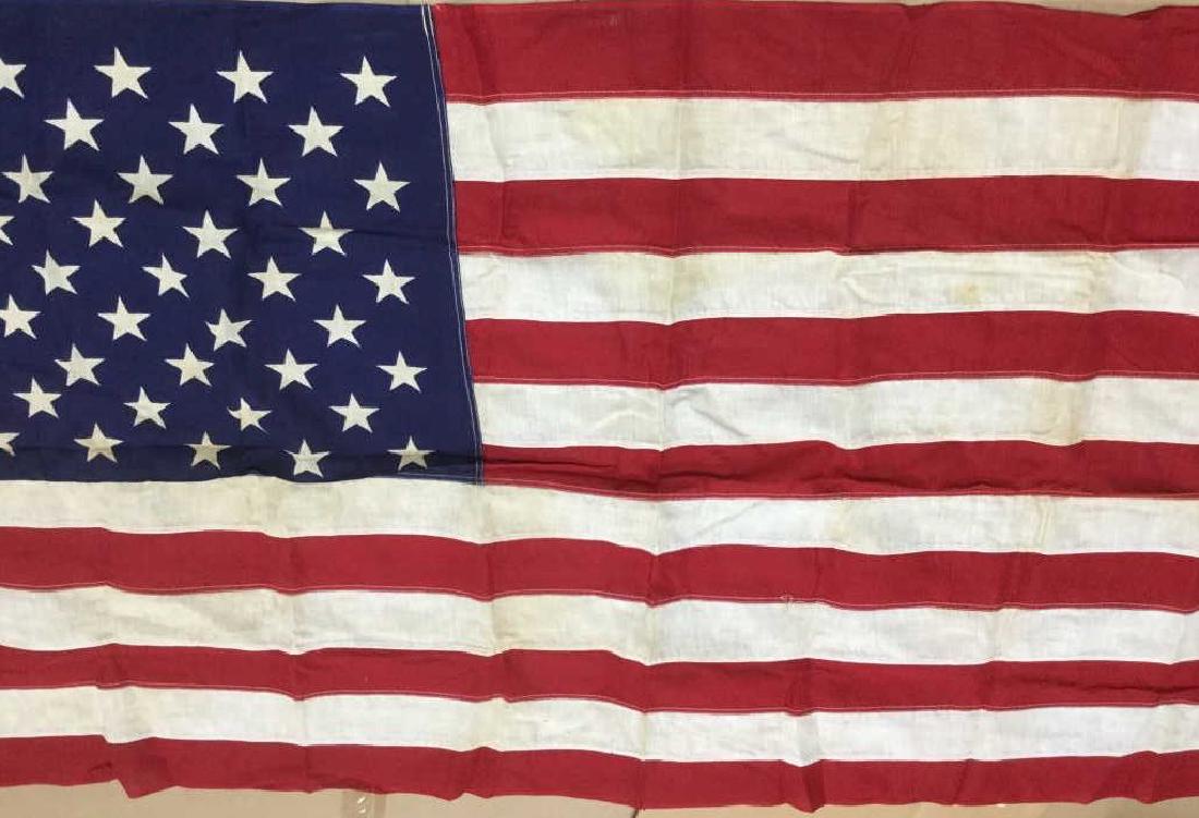 Vintage U.S. American Flag: Vintage sewn U.S. American flag. Measures approx 58.5 inches by 33 inches in length and width. Flag has surface wear like discoloration consistent with outdoor exposure and age. Might need cleaning. V