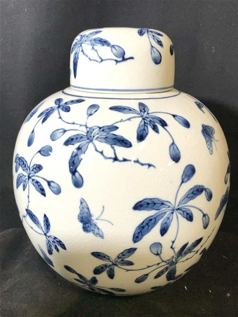 Porcelain Asian Style Ginger Jar: Piece is porcelain. Contains blue toned vine, leaf & butterfly detail. Measures approx 10.5 inches tall 9 inches wide. Asian Urn, Urn With Lid, Tabletop Accessories. ginger jar, tableware, shelf piece