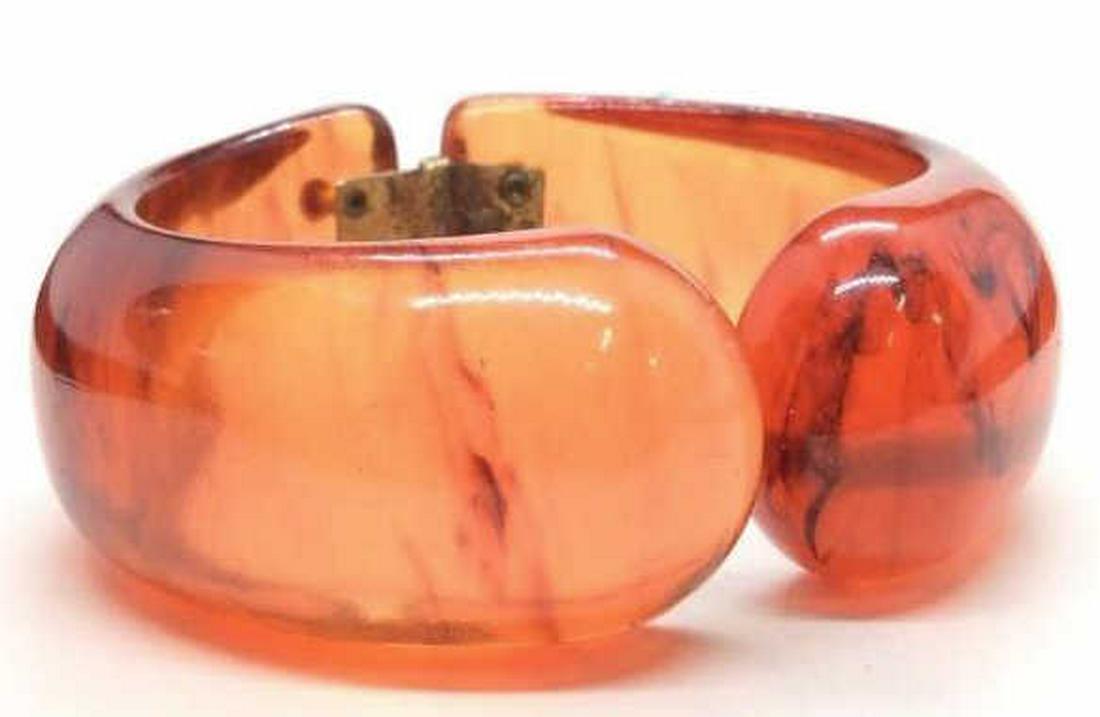 Bakelite Bangle Bracelet: Hinged bracelet with smooth organic form, Retro, art deco style jewelry. Orange toned material, appears to be Bakelite, evident discoloration to metal hinge, Bakelite appears to Ben in good condition,