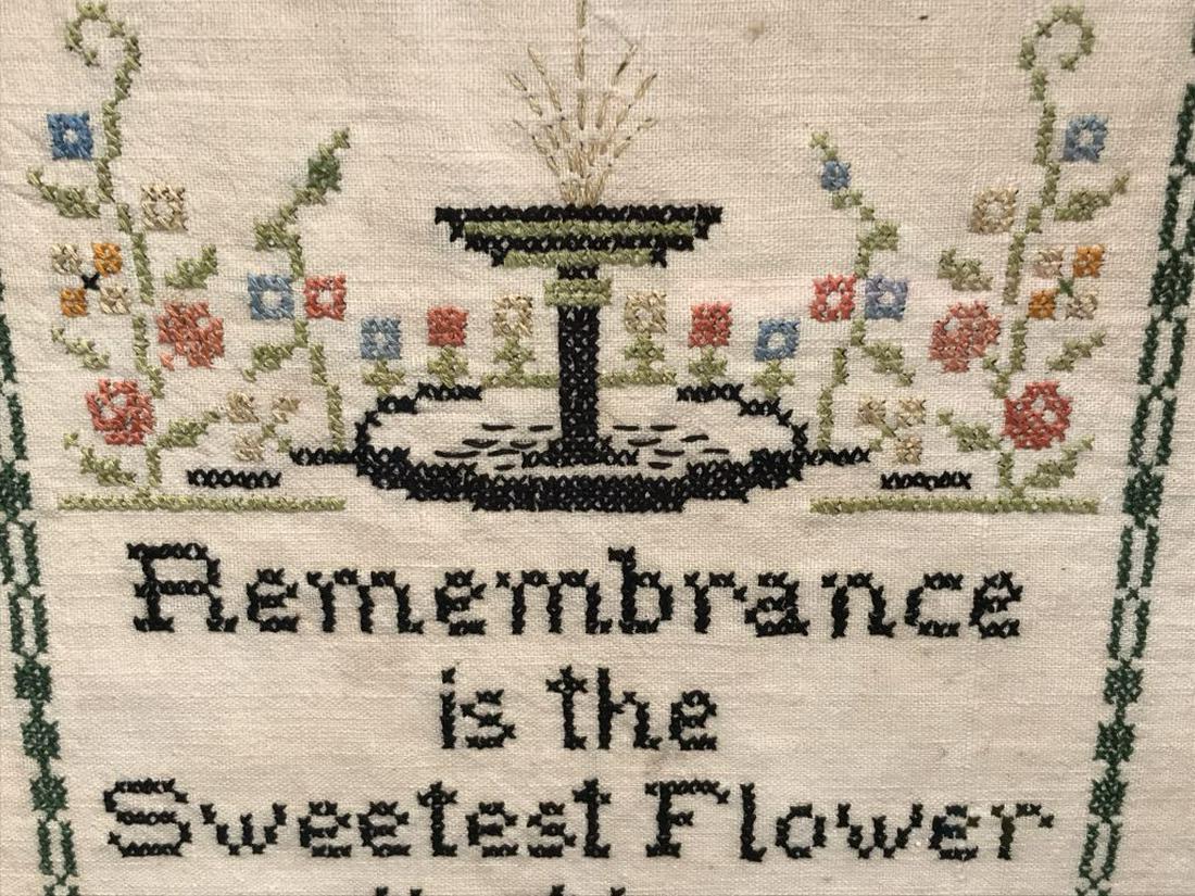 Vintage Colonial Motto Sampler, Sweetest Flower: Sampler features the saying ‘remembrance is the sweetest flower that in a garden grows.’ Embroidered fountain and fence motifs with patterned border. Sampler is set behind glass in wood frame. Fra