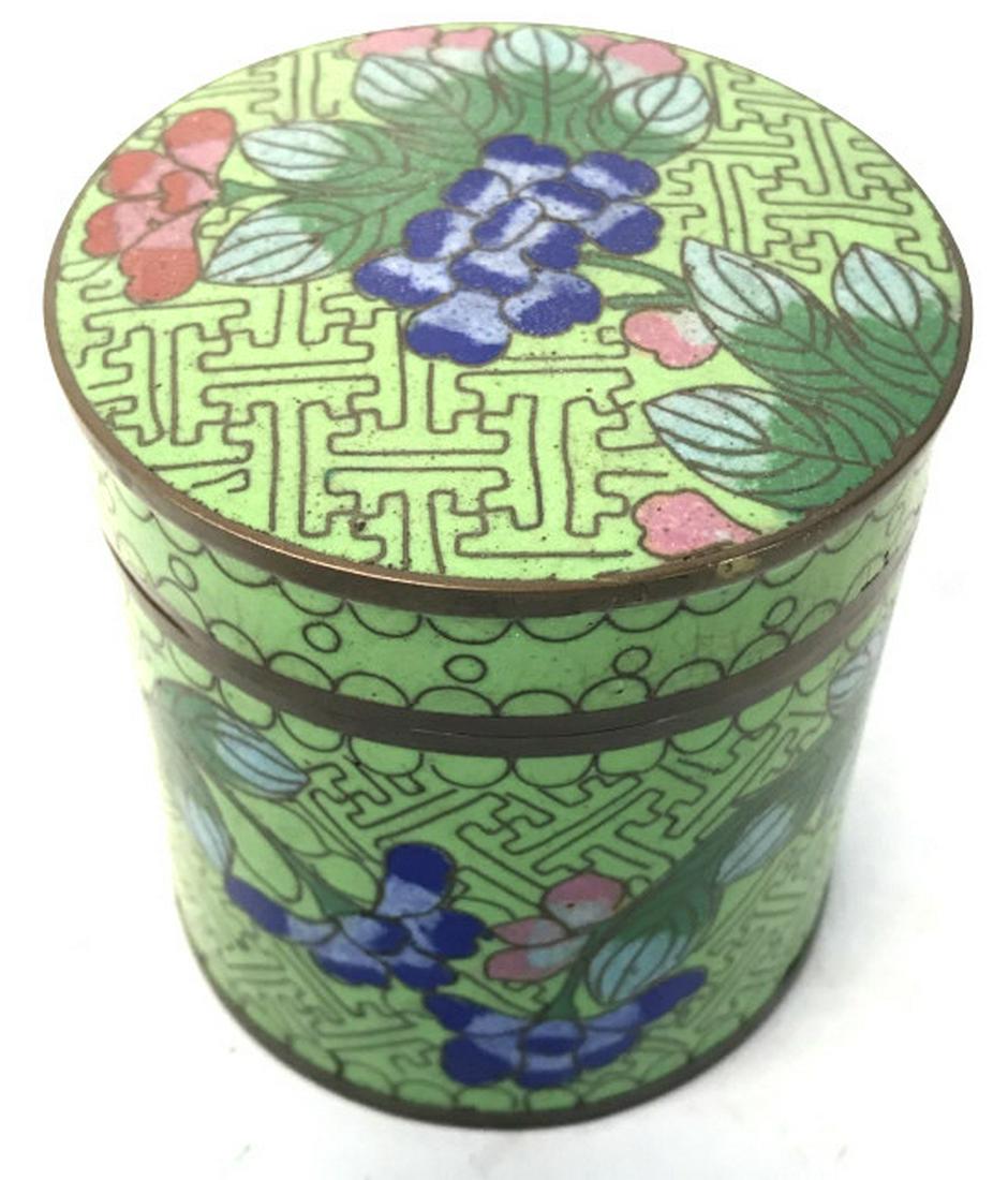 Cloisonné Enameled Cylindrical Keepsake Box: Piece is green toned with multi toned floral and leaf detail with tones of yellow, light blue gold, pink and royal. Piece includes lid. Piece has a cylindrical shape. Measures approx 3.5 inches tall 3
