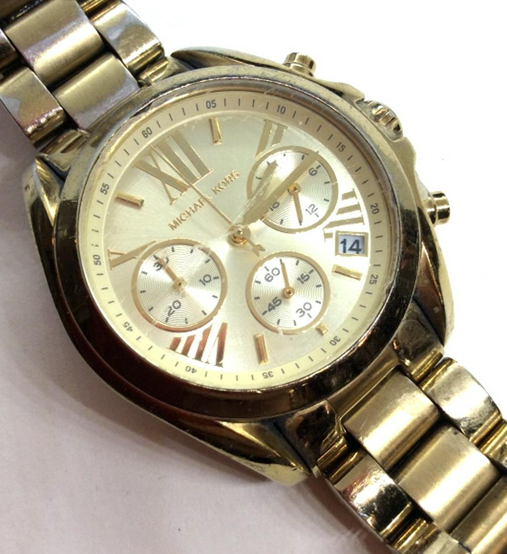 MICHAEL KORS Gold Toned Wristwatch: Gold toned metal Wristwatch. All stainless steel Wristwatch. Appears to be in working order. Measures approx 3 in in diameter. Some wear to metal and scratches to watch face. Fashion accessory, wearab
