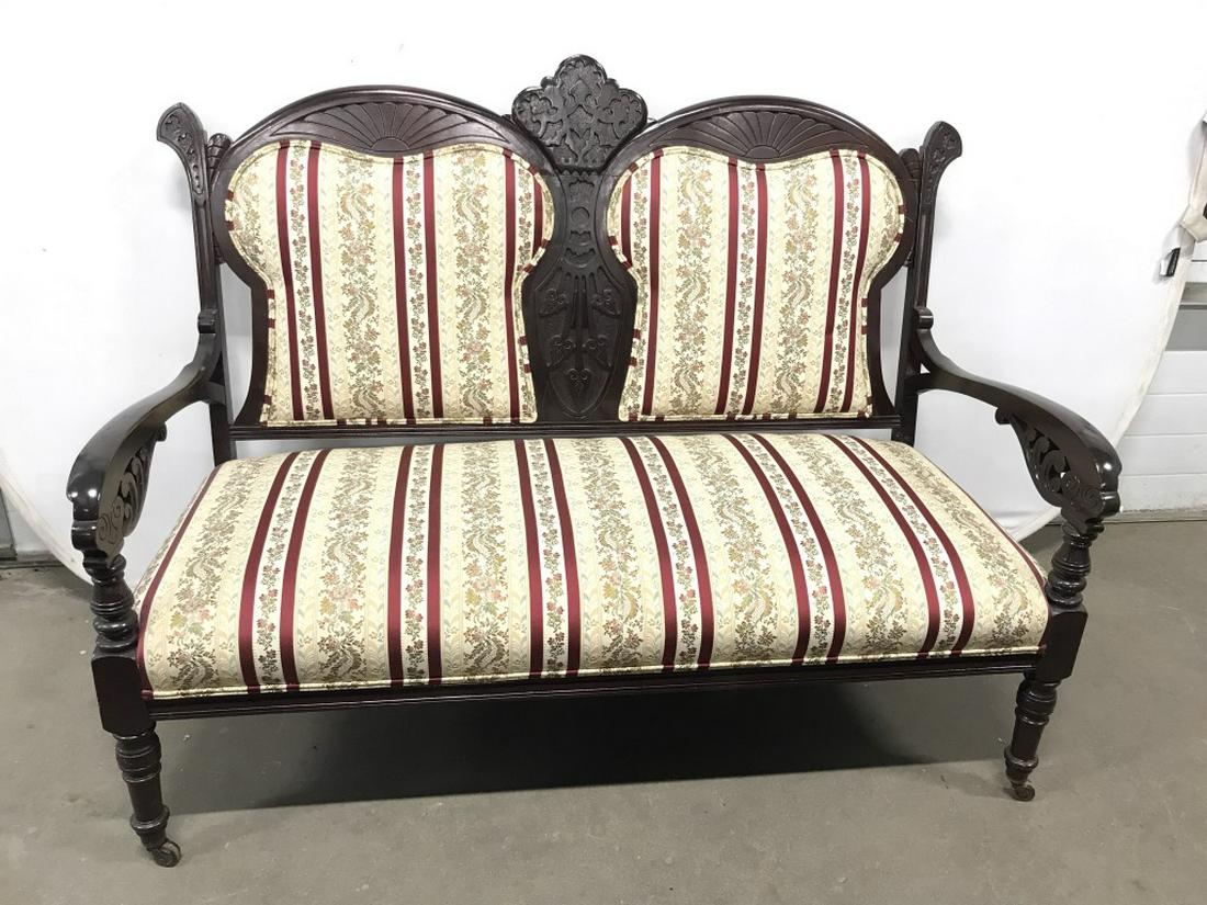 Victorian Carved Wooden Settee Loveseat: Victorian Wooden Settee Loveseat on caster feet, Upholstered seat and back with double welting, minor surface scratches, measures approx 51 inches wide x 26 inches deep x 39.5 inches tall at back. Eas