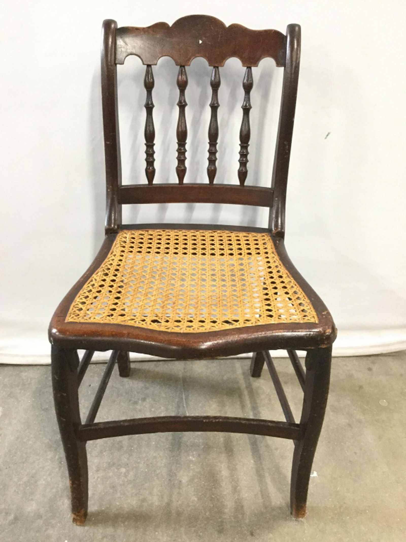 Vintage Caned Wooden Side Chair Side chair is brown: Side chair is brown toned and wooden. Seat is Caned. Backrest Of Seat has carved wooden detail. Measures approx 32 inches tall 18 inches wide 20 inches deep. Contains evident wear and scratches. 6.