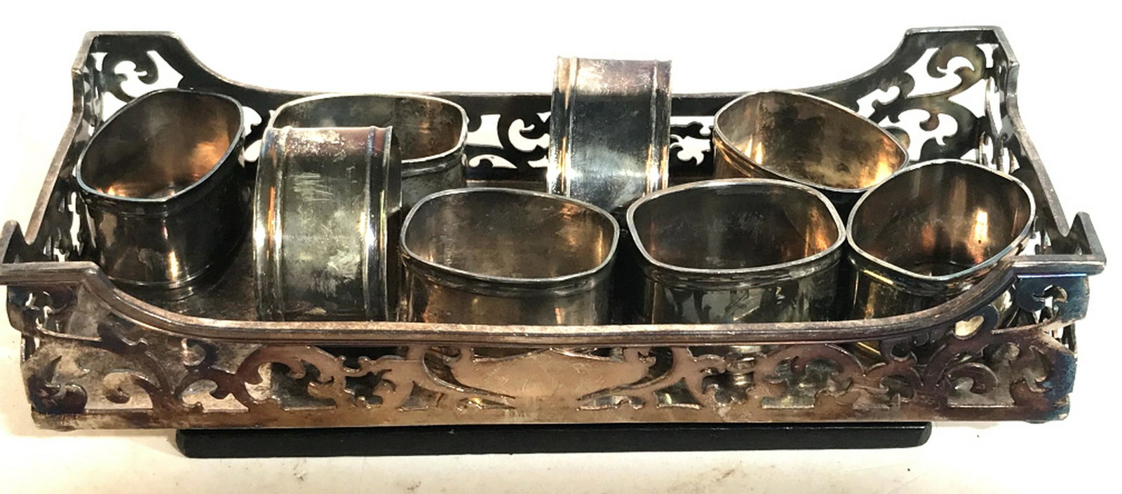 Silver Plated Napkin Rings W Art Nouveau Tray Lot 9,: Lot 9, Tray is Meriden & R. Company, USA Plate, Rodgers Brothers. Tray measures 9 1/4 x 4 in. Slight bend on a side. 8 napkin rings, unmarked, opening approx 1 7/8 x 1 1/4 in. All have discoloration. 