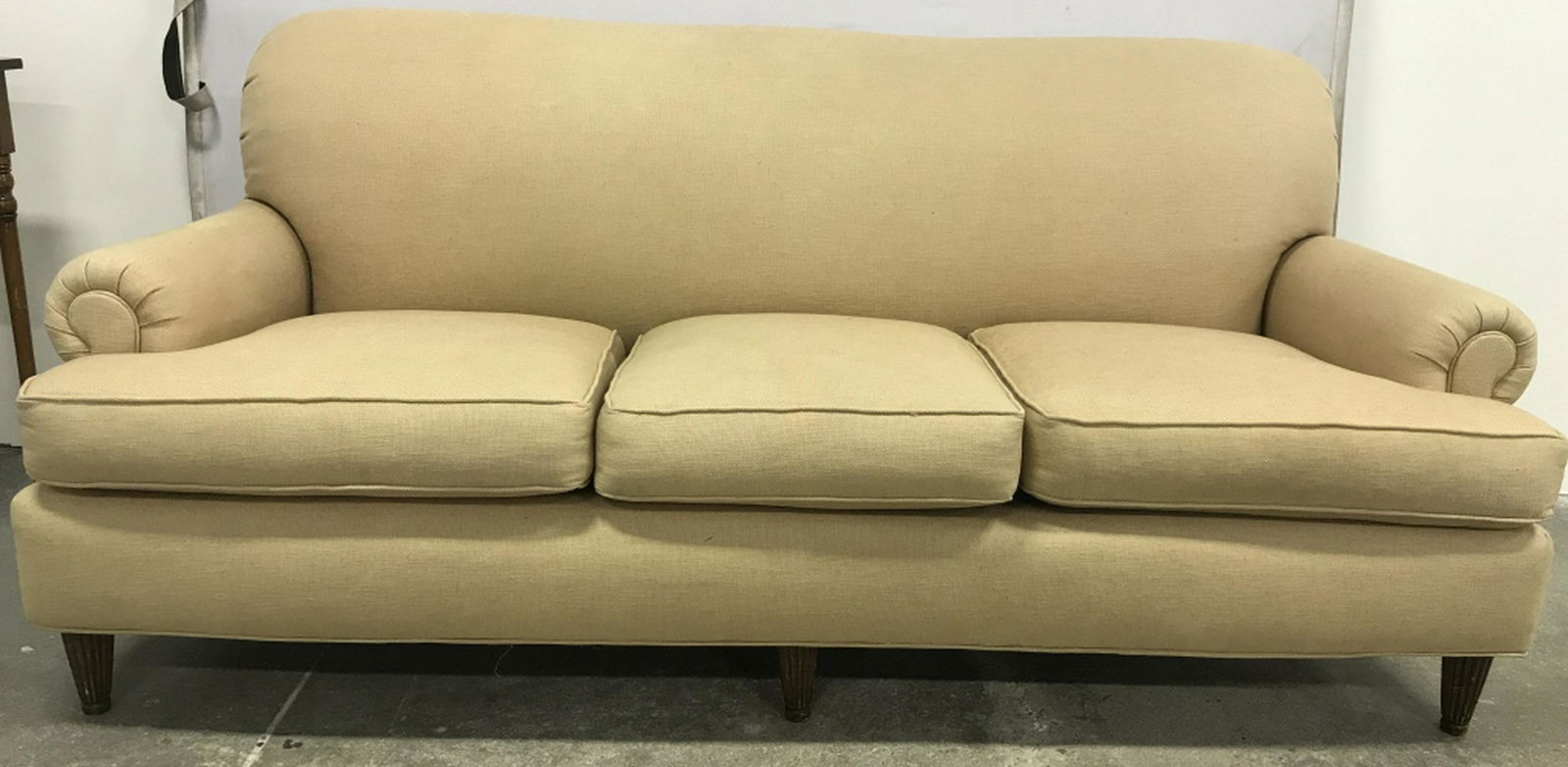 Beige Toned Footed Sofa Sofa is beige toned. Contains 3: Sofa is beige toned. Contains 3 cushions. Piece has brown toned carved wooden feet. Measures approx 81 inches long 37 inches tall 40 inches deep. Piece has some wear may need some restoration. Sofa, c
