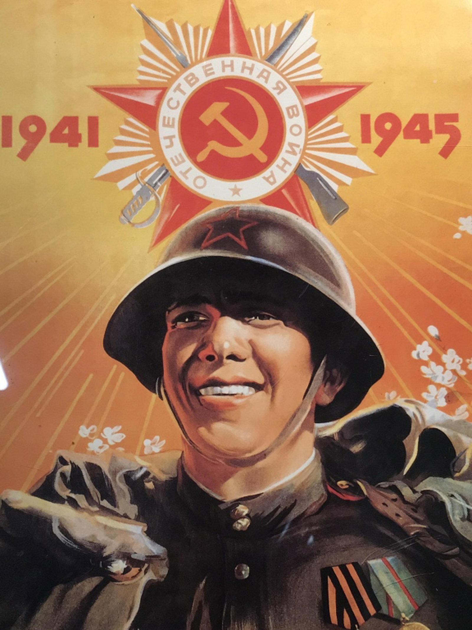 Framed Russian Soviet Propoganda Poster Framed 1995: Framed 1995 poster print of a Russian Soviet Propoganda poster depicting a young soldier under the hammer and sickle with dates 1941 - 1945. Type in Russian Cyrillic below image. Poster print is mount