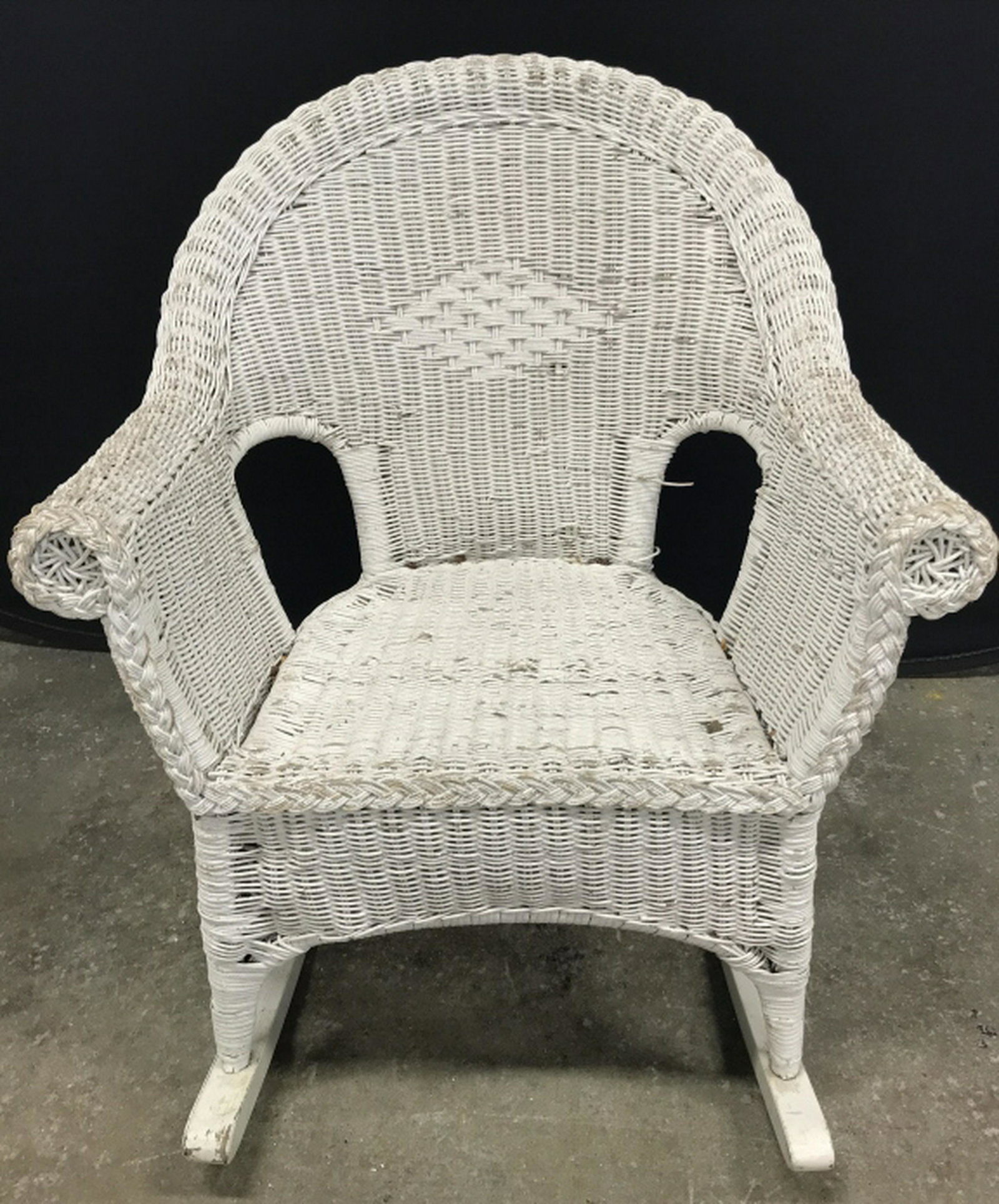 Vintage Wicker Rocking Chair: Vintage rocking chair is painted white in tone. Measures approx 36 inches in height by 28 inches in width by 35 inches in depth. chair has surface wear like discoloration and chips in paint. Vintage w