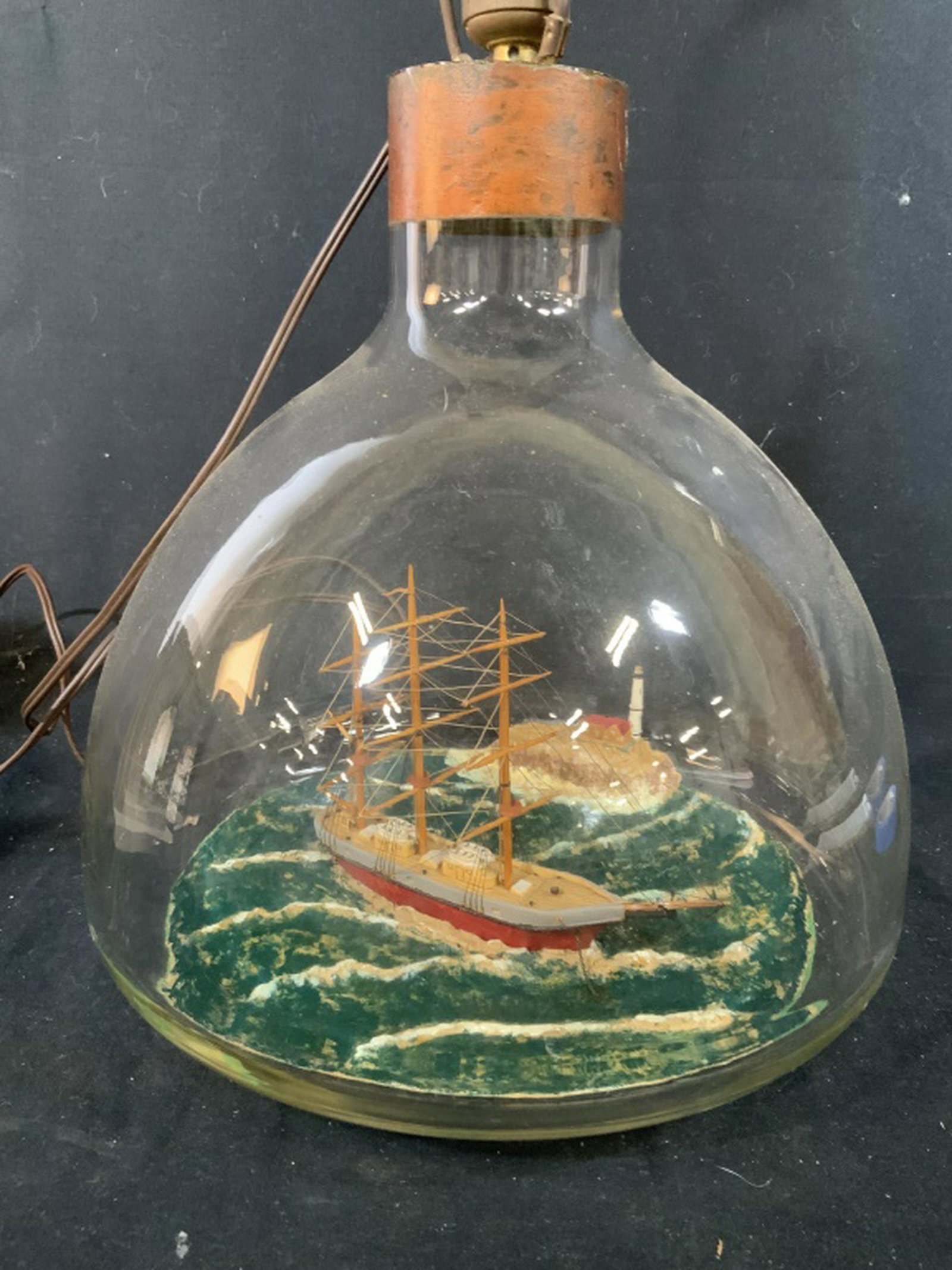 Ships in a Bottle Unique Lamp: Large glass bottle with metal top encases scene of sailing vessel at sea lighthouse on a cliff scene arts and crafts, folk art, nautical scene, maritime collectible, ht to top of glass 13 inches diame