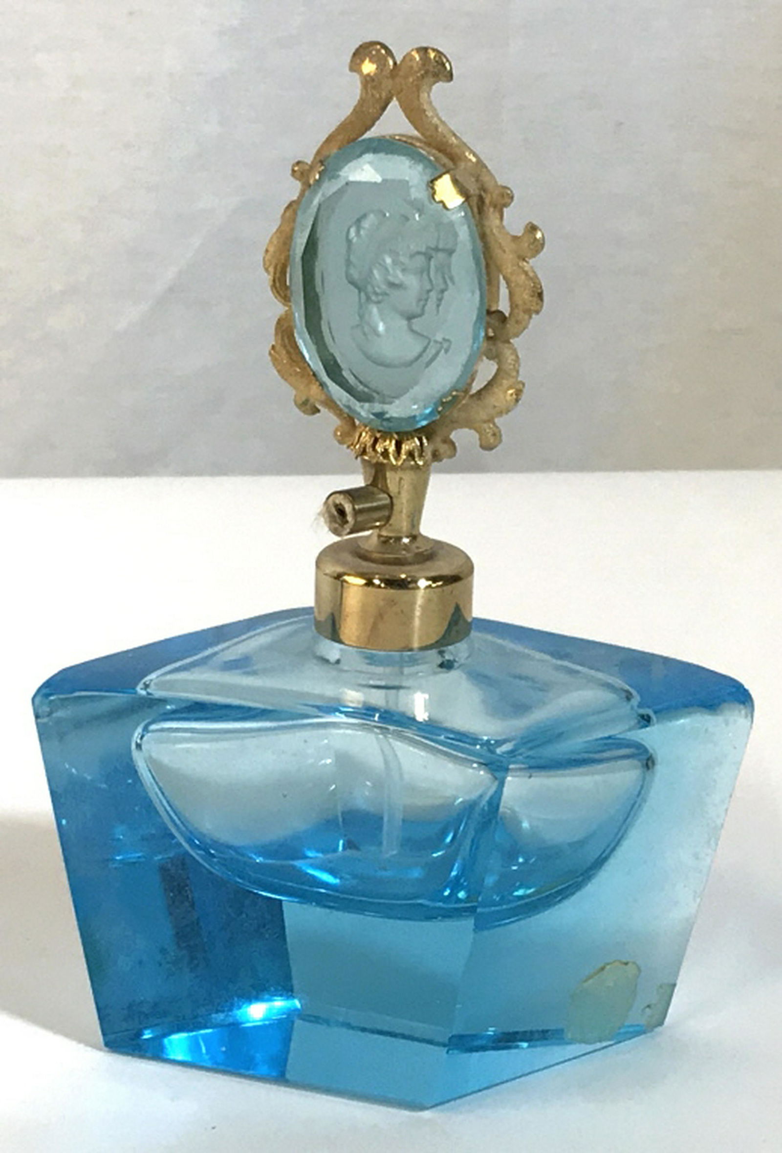 Vintage Cameo Finial Trapezoid Shape Perfum Bottle: Bright Blue Bottle With Gold Tone Accents. Carved Cameo, Possibly resin Material. Originally a spray bottle, does not function. Approx 4 in. wide, 6 in. tall, approx 2.5 in width. Perfume Bottle, Vint