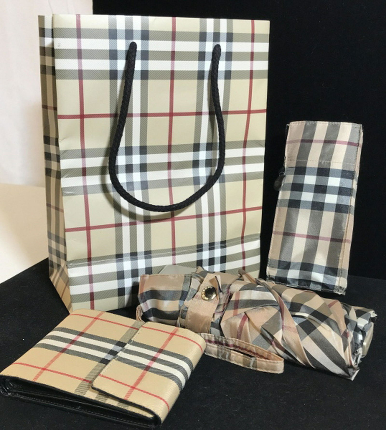BURBERRY Classic Check Accessories In ORGINAL Bag: Burberry Snap Close Wallet And Microlite Burberry Umbrella In orginal Packaging with skew sticker. Hallmarks on some snaps & on interior of Wallet. Wallet hold paper money, CC’s, ID, Measures 4.5 x