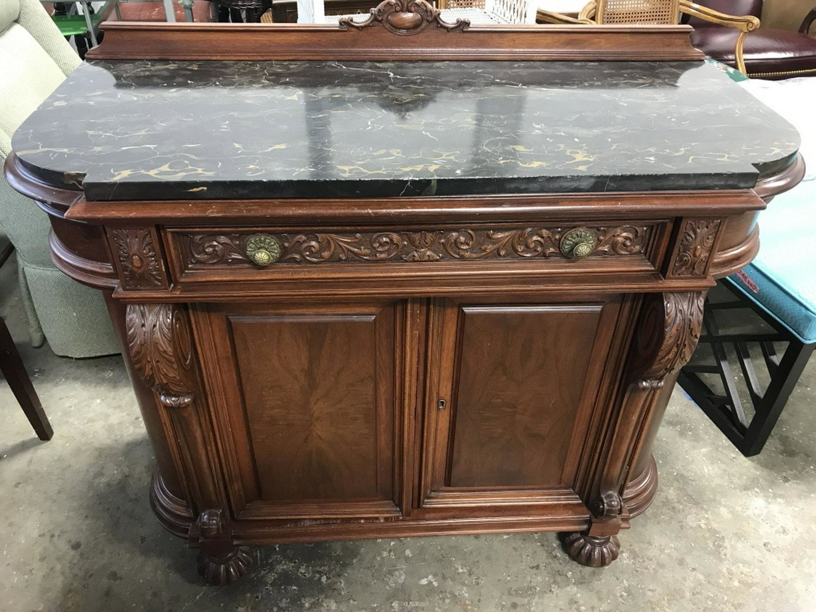 Daniel Jones Vintage Wood Sideboard W Marble Top Verso: Verso marked for DANIEL JONES. Vintage carved wooden sideboard w dovetail jointed frieze drawer and 2-Door bottom cabinet w interior shelf. Marble top is black in tone with golden honey and white tone