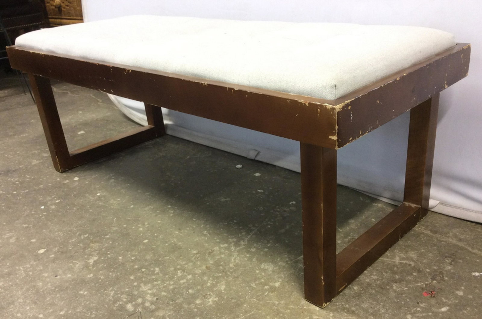 Vintage Bench W Grey Toned Upholstered Cushion Bench: Bench appears to be vintage. Cushion is Upholstered with grey toned cushion. Piece measures approx 46 inches long 20 inches deep 18 inches tall. Contains evident scratches and minor chips. Home accent