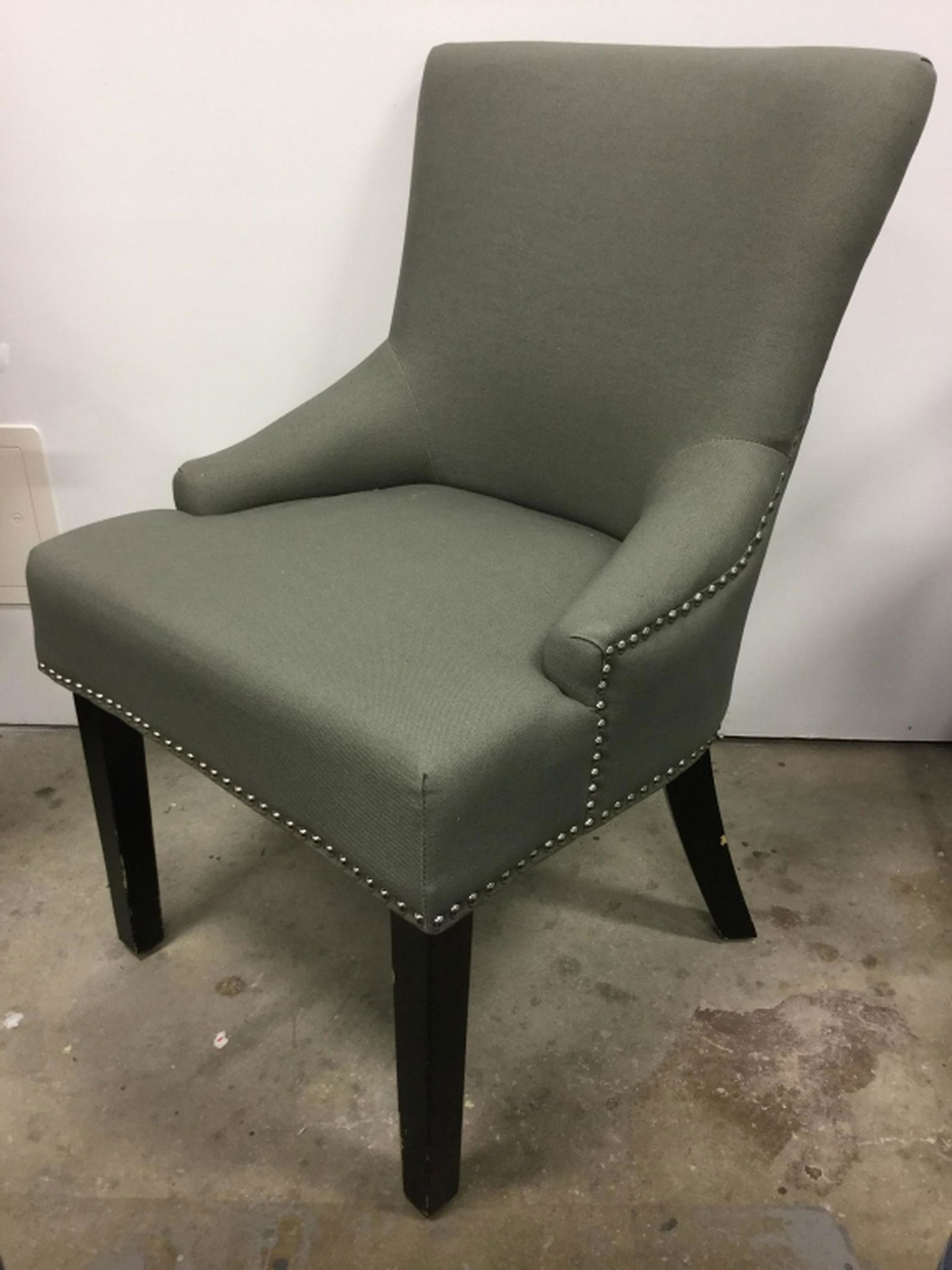 Upholstered Gray-Green Dining Chair Chair is gray-green: Chair is gray-green in tone. Silver tone tack details. Undersides are marked for SAFAVIEH. Chairs has some surface wear, including blemishes and scuffs on legs. Might need spot cleaning. Measures appr