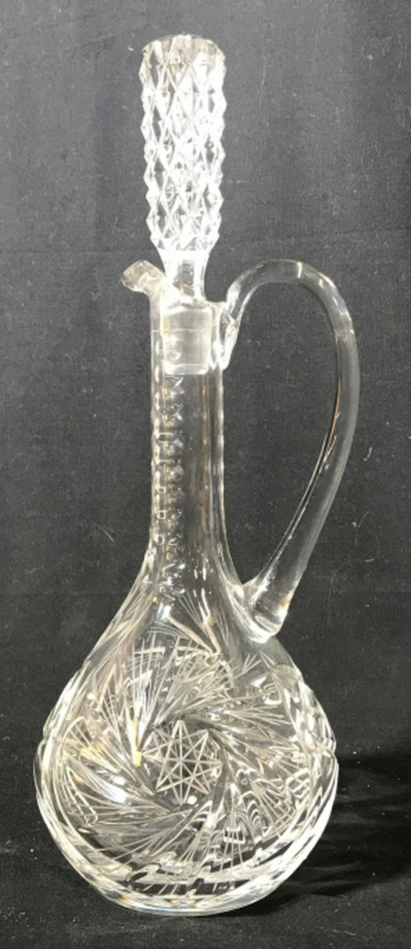 Cut Glass Decanter with Pour Handle & Stopper Etched: Etched star shapes on body and diamond cut on stopper. Spout and long pour handle. No chips or nicks. 14.5 in. Height with Stopper. Circumference Of rounded bottom is 17 in. Barware, Decanter, Estate 