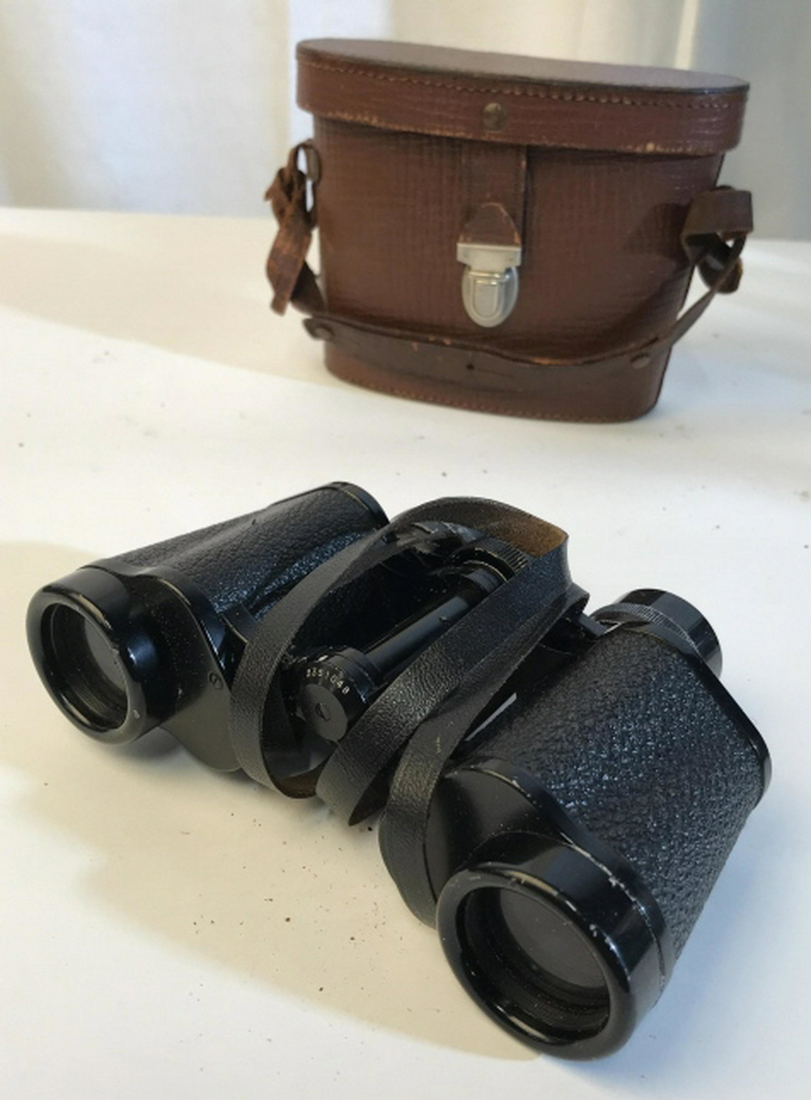 Vintage binoculars with case Vintage binoculars with: Vintage binoculars with case. Case is possibly constructed out of leather. Case stands at approximately five inches in height and eight inches in length. Bolt missing on one side of the case. Binocula