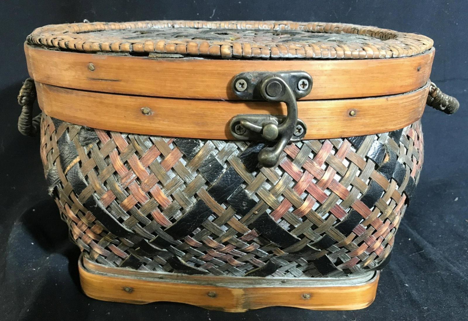 Handmade Woven Storage Table Basket criss cross Weave: criss cross Weave with lifting handles and a latch to secure close. Hinge opening with added ribbon secured to support lid when opened. no noted conditions. Approx measurements - 12 x 9.5 x 7. Woven B