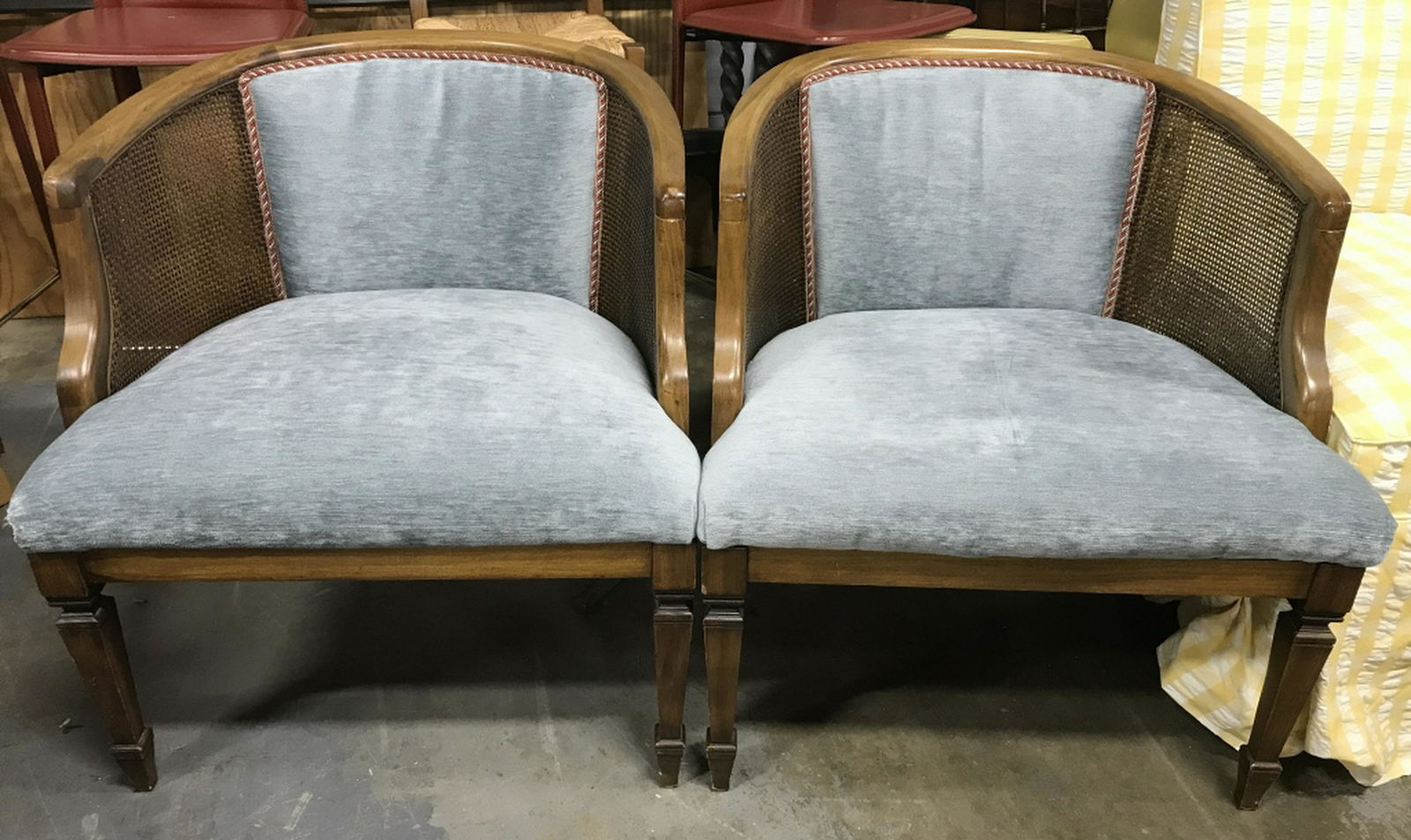Pair Upholstered Caned Curved Back Chairs Lot includes: Lot includes 2 chairs. Each have caned backrest with cushion in center. Pieces have light slate blue toned upholstery. Each measures approx 29 inches tall 26 inches wide, 25 inches deep. arm chairs, d