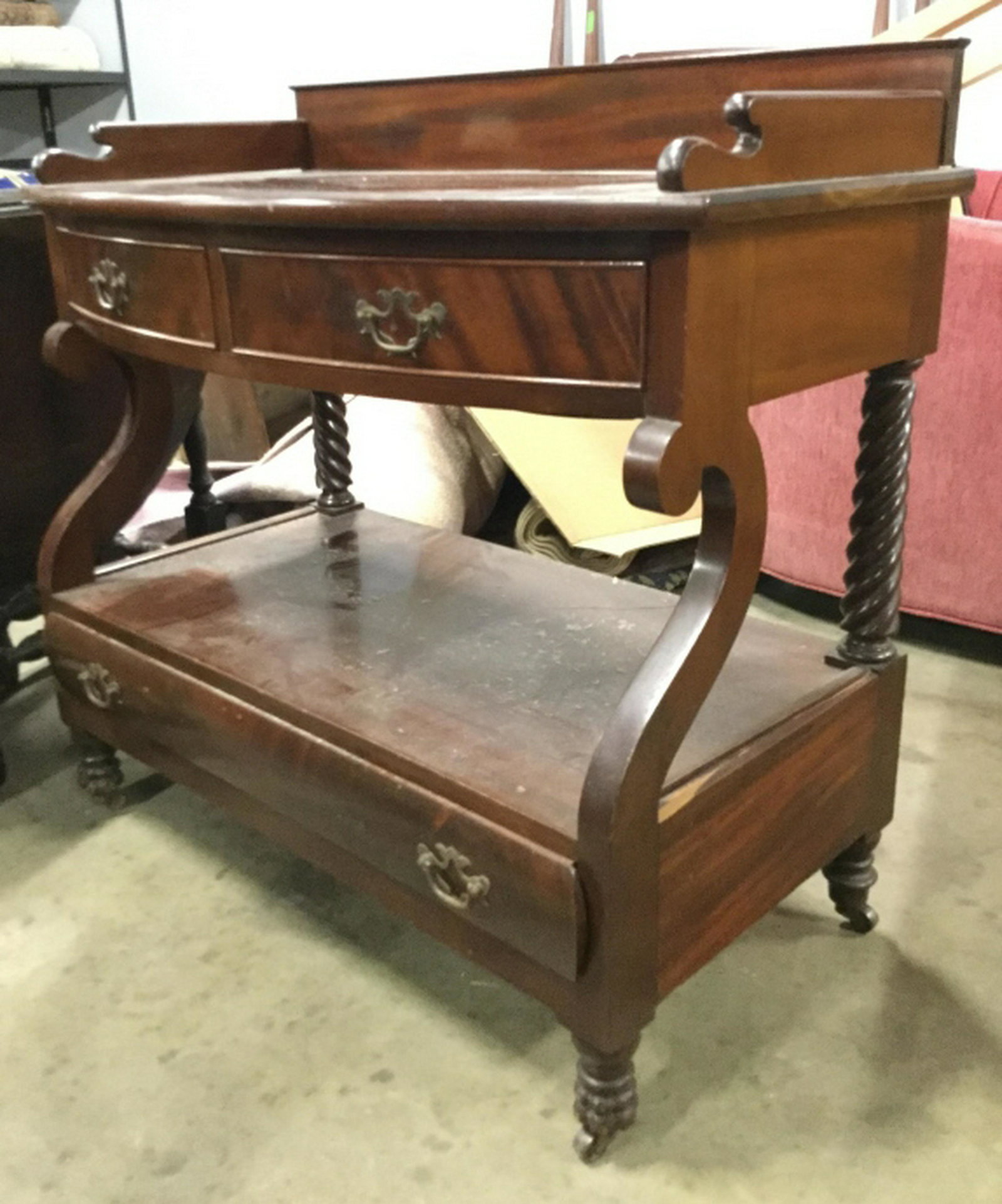 Mahogany Toned Vintage Sideboard On Casters Piece has: Piece has carved wooden detail. Piece is possibly mahogany. Sideboard contains 2 small top drawers and 1 large lower drawer, each drawer has metal handles. Piece sits on casters. piece measures approx