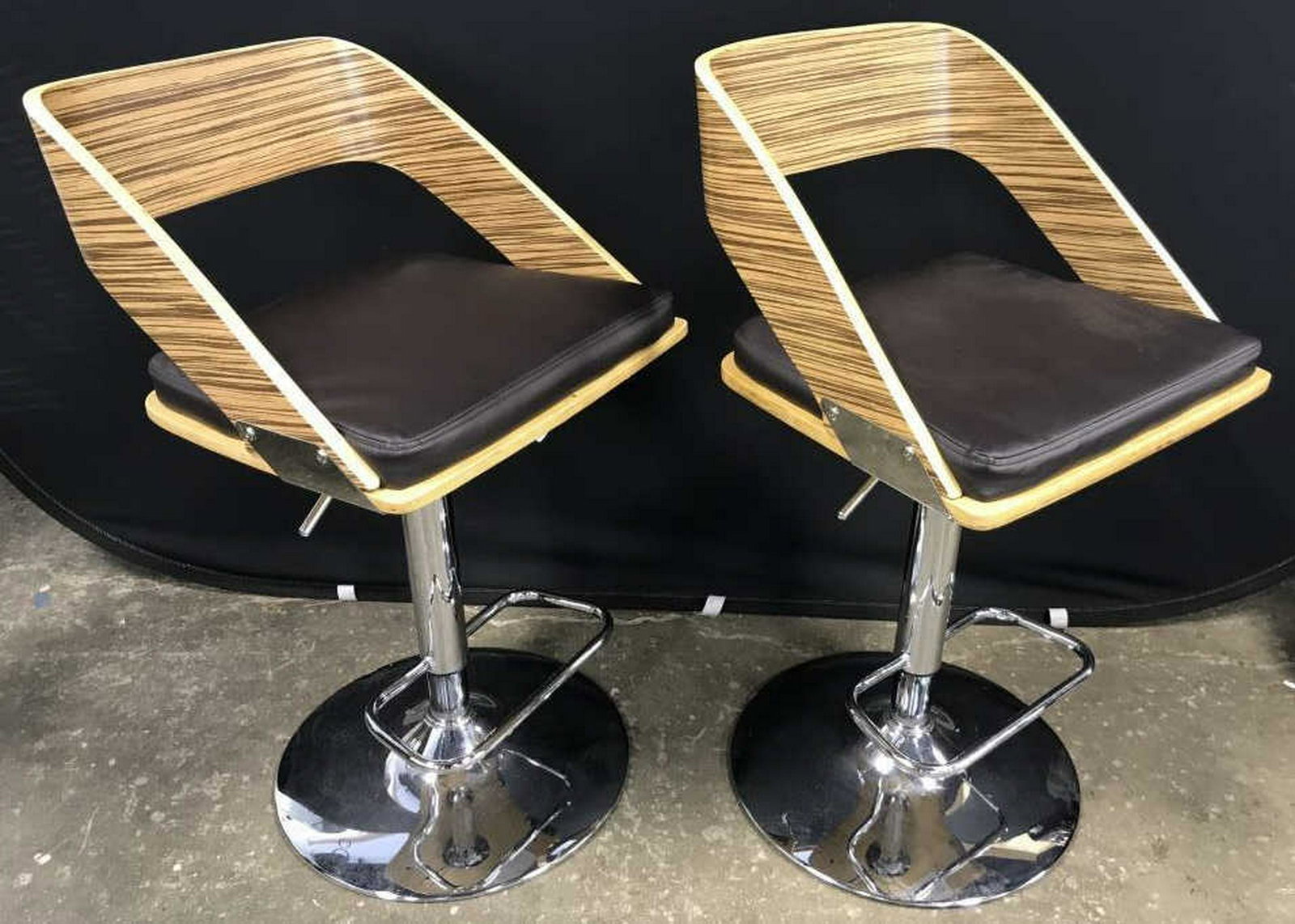 Pair Modern Wood & Chrome Adjustable Bar Stools Pair of: Pair of modern contemporary adjustable bar stools with wood-style seats w leather-style deep brown tone cushions. Seats sit atop chrome bases with lever for adjusting and foot rest. Each measures appr