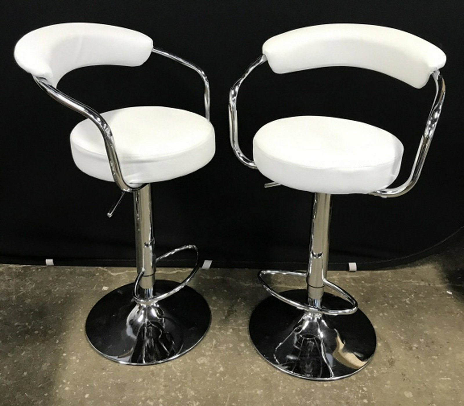 Pair Modern Chrome Framed Adjustable Bar Stools Pair of: Pair of modern style adjustable bar stools with gray-white tone leather-style upholstery. Seats have chrome frame. Lever for adjusting with foot rests. Each measures approx 34.5 inches in height by 20
