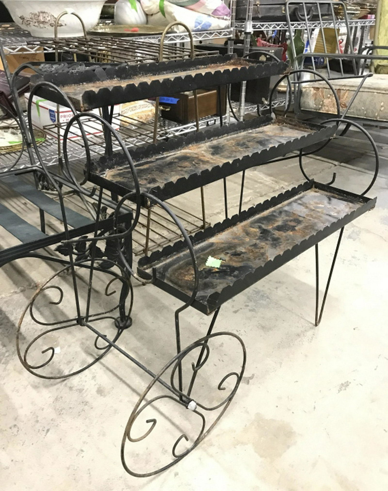 Outdoor Black Toned Metal Planter Stand Cart Piece has: Piece has 2 metal wheels each with C curve detail. Piece has 3 levels and 1 handle opposite of wheels. Piece measures approx 33 inches long 25 inches tall, 17 inches deep. Planter cart, drinks cart, p