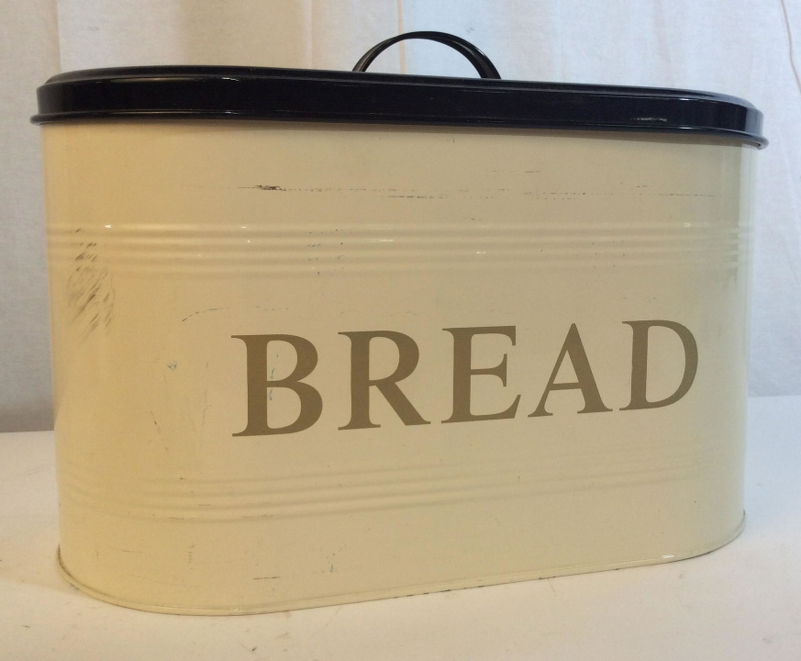 Vintage large breadbox Vintage large bread box with: Vintage large bread box with removable lid. Breadbox measures approximately 13 inches by 7 inches by 10 inches in height. Box is a cream color with a black lid. Handle measures approximately 1 inch ta