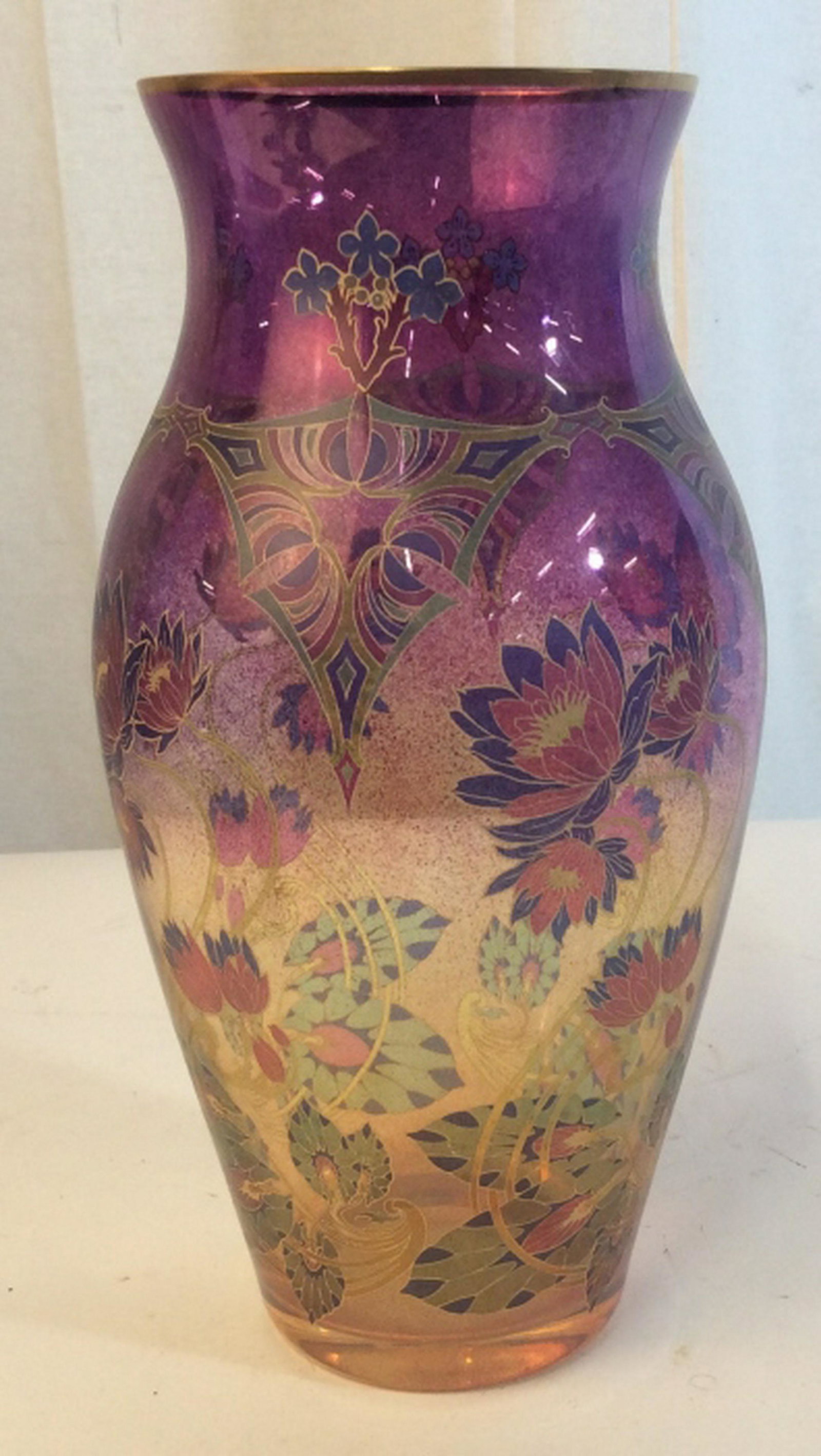 Vintage tall colorful vase Vintage tall colorful vase.: Vintage tall colorful vase. Fades from purple at the top to yellow at the bottom. floral Pattern throughout design of vase gold colored accents. Vase stands approximately 12 inches tall and 7 inches w