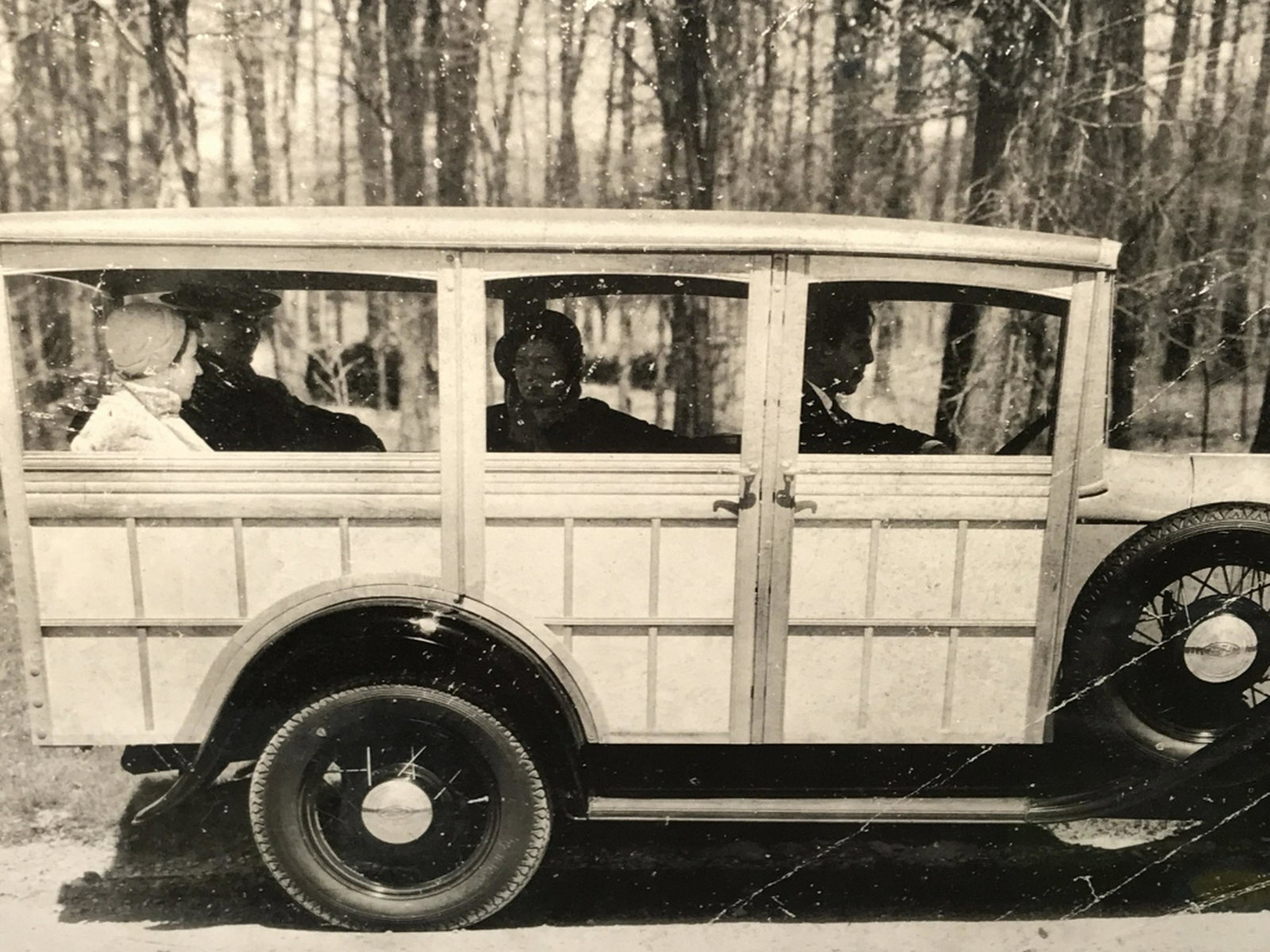 Framed Vintage B&W Photograph Poster Print Print: Print depicts figures in vintage car. Print is double matted and set behind plexiglass in black tone metal frame. Measures approx 18.5 inches in height by 22.25 inches in width with frame. Decorative