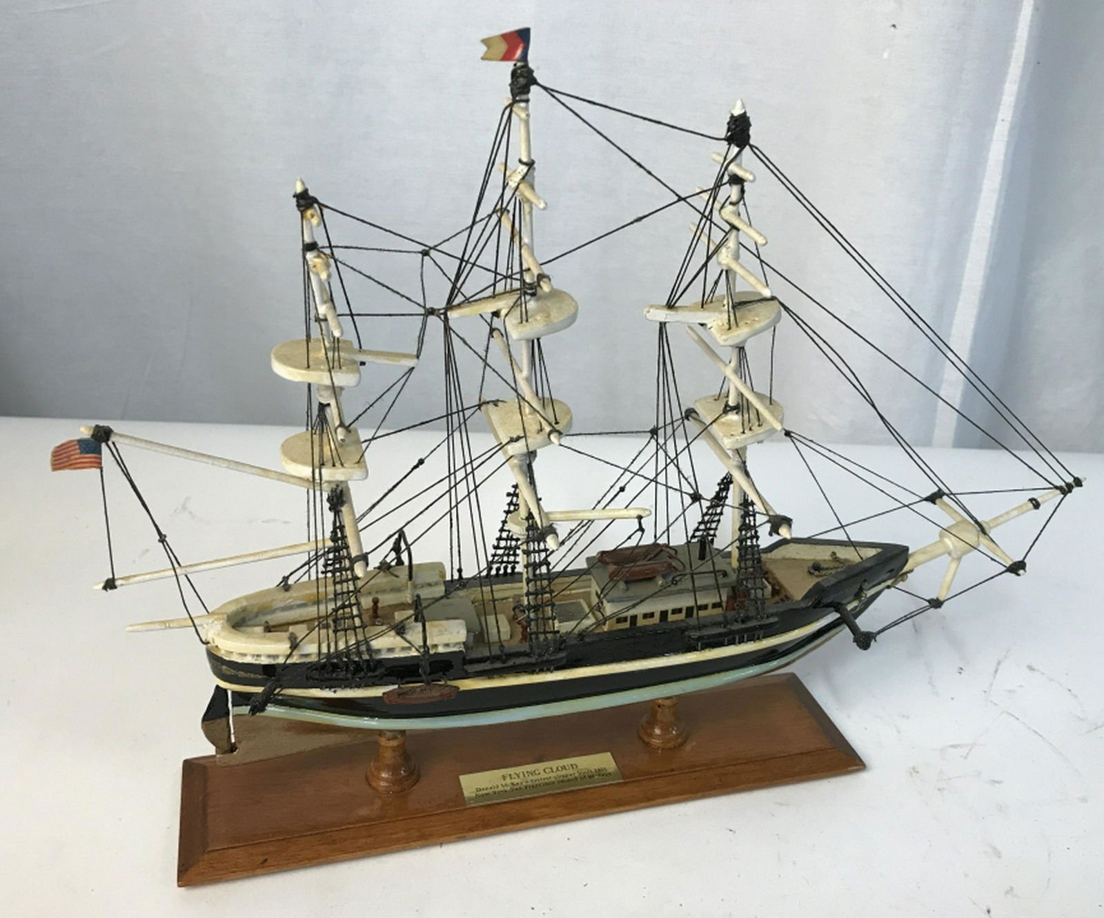 Small nautical model vessel Vessel labeled “Flying: Vessel labeled “Flying Cloud”. Hand painted and detailed. Made with wood, plastic, and string. Stands approximately 10.5 inches at max height and 15 inches at max length. Moving rudder. Bottom lab