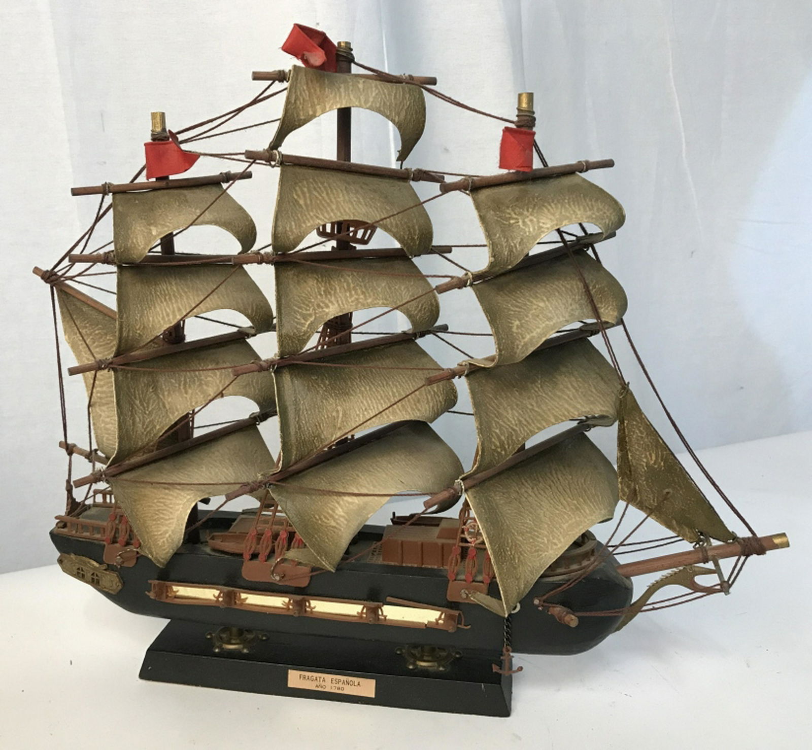 “Fragata Espanola” Spanish nautical model vessel: Fragata Espanola model ship dated 1780. Ship is hand painted and made out of plastic and string. Black ship with brown, gold, and red colored detailing. At max height stands approximately 14 inches. A