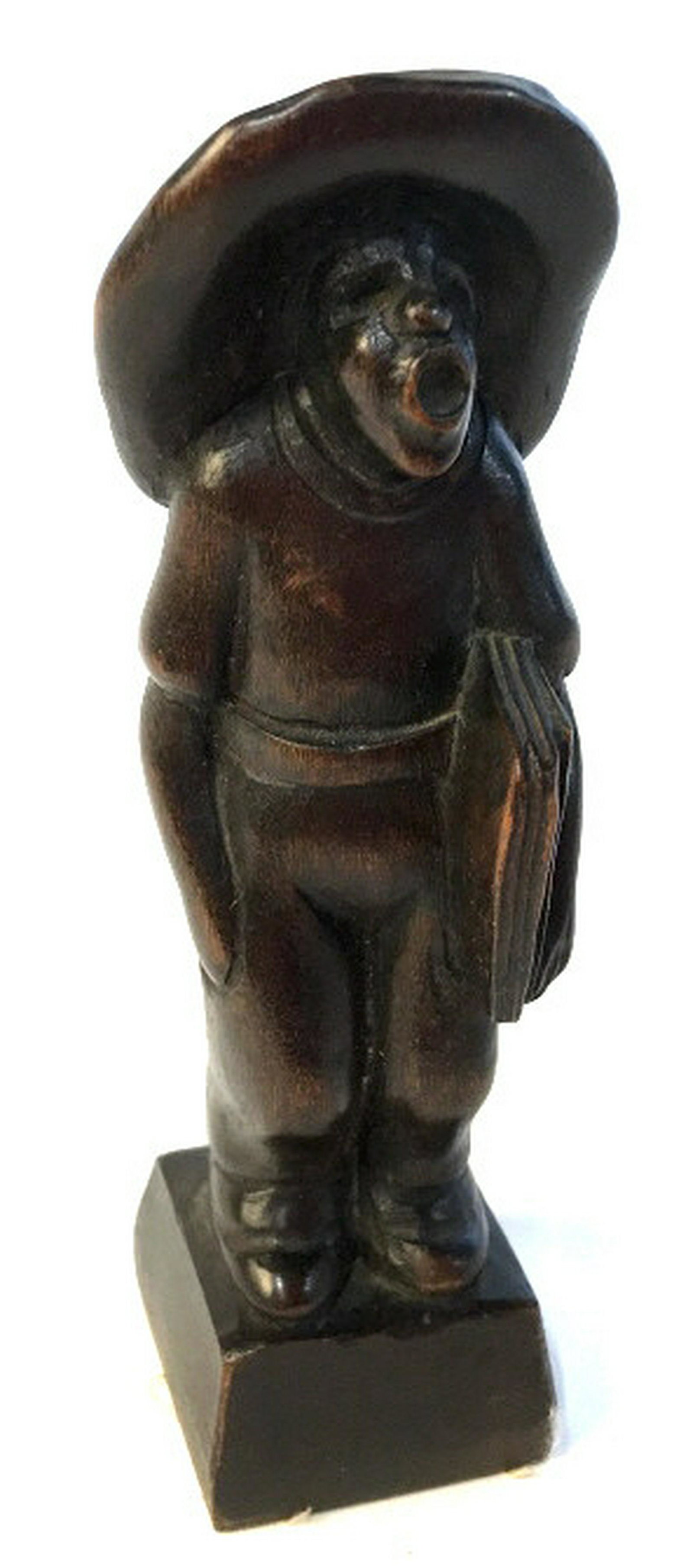 Wooden carved farmer sculpture Carved into dark wood: Carved into dark wood with a small chip in the back. Artist’s name is carved in on the back of the base of the sculpture. Sculpture stands approximately 7 inches tall. Sculpted farmer singing while 