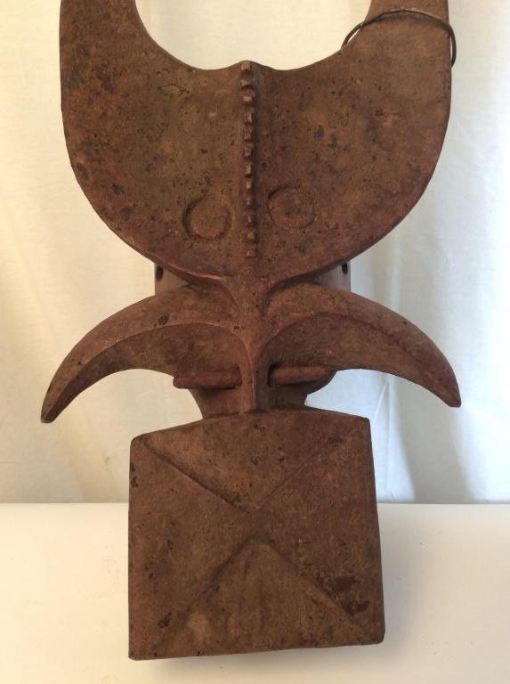 African Art Mama Tribe Buffalo Dancing Mask Large: Large Zoomorphic helmet mask, headdress of buffalo or bush cow from the Mama tribe in Nigeria. Mask is carved wood with reddish coating. Mask features elongated horns that form an oval shape, descendi