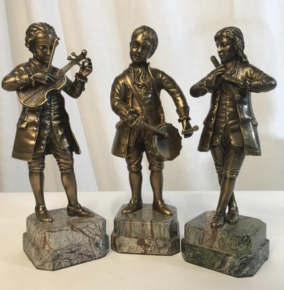 Set 3 Bronze Figurines on Stone Bases, Musicians: Set of 3 bronze Figurines on stone bases, depicting musical trio playing the drums, violin, and flute. Each sculpture measures approx 10.75 inches in height by 3.25 inches squared in length and width.