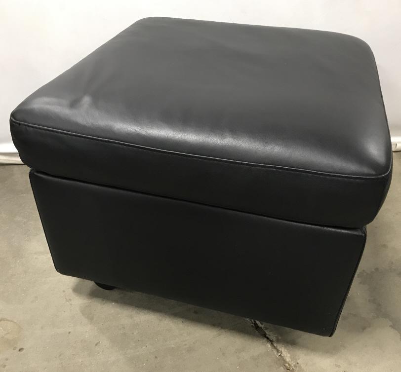Pair EKORNES Stressless Leather Storage Ottomans: Pair of EKORNES fully leather lined storage Ottomans with cushion tops. Marked on undersides for EKORNES. Black tone leather. Ottomans sit on wheels. Each measures approx 18 inches in height by 23.5 i