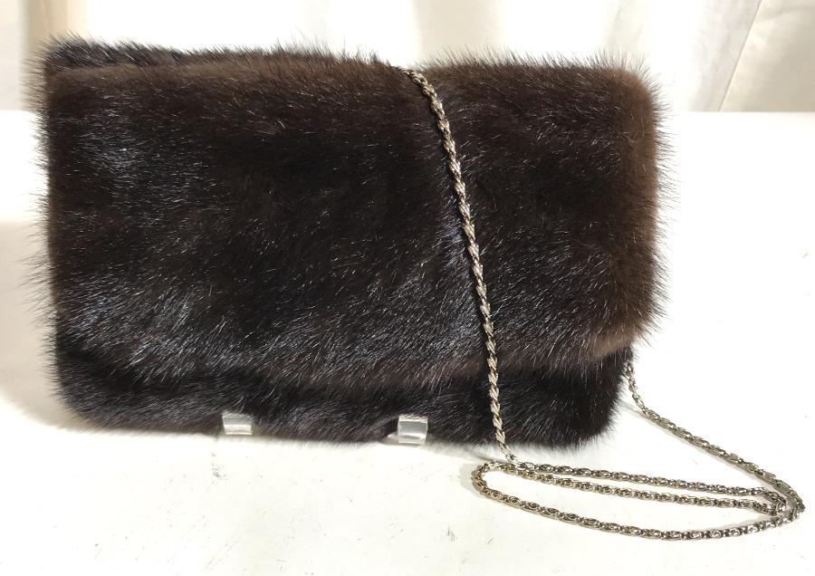MINK FUR Chain Shoulder Bag/ Clutch: Fur handbag with silver tone shoulder chain. Hangs 19 in. Purse measures 10 x 7 x 1 in. Snap closure. Chain can be tucked away to use as a clutch bag. ‘V’ opening, with max width at 3 in. Fur Shou