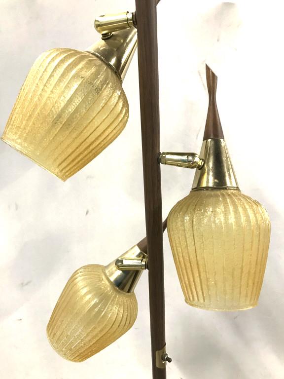 Danish Modern Eames Era Floor Lamp W Glass Shades: Danish modern Eames Era Floor Lamp. Lamp pole appears to have wood style veneer. Finials appear to be wood, possibly teak, with brass Details. 3 Honey yellow toned ribbed glass shades. Lamp has not be