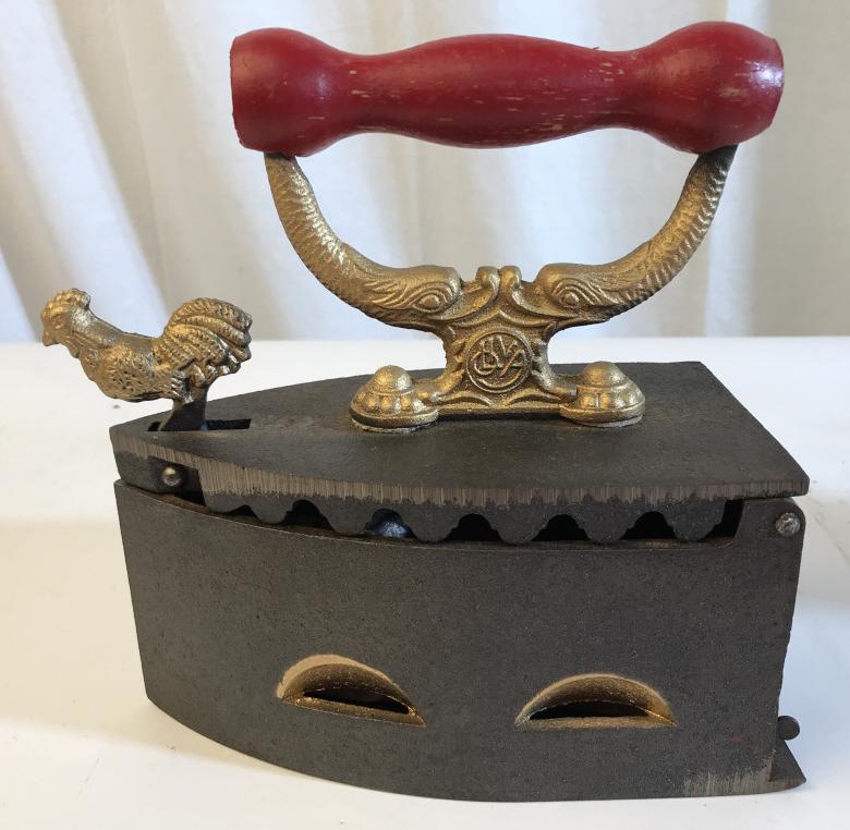 OLIVIA VINTAGE SAD IRON: Olivia logo present in the back of the iron as well as under the lid. Illegible name underneath logo. Iron is approximately 8 inches in length and 9 inches in height. Gold toned accents. Red, gold and