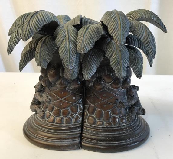 Tropical Palm Tree with Monkey Bookends: Palm Tree bookends. Bookends each have a monkey and coconuts on the trunk. Brush strokes on ends indicate that it was hand painted. Heavyweight composite material, minor surface wear. Brown and green,