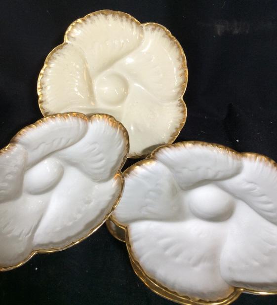 Set 4 floral ceramic serving plates: Flower design serving plates. Each plate has 6 indents for separate objects. 1 Plate is beige with a gold painted outer rim while the other three are white with a gold colored outer rim. Each plate me