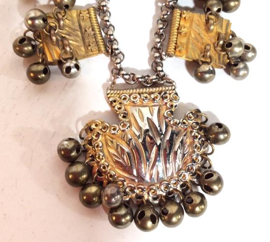 Silver Toned Metal Necklace: With brass toned details, Sculptural bead sections with hanging bead clusters, etched shell shaped pendant tribal inspired design, some missing beads, Measures approx 10 in long. Women’s vintage cos