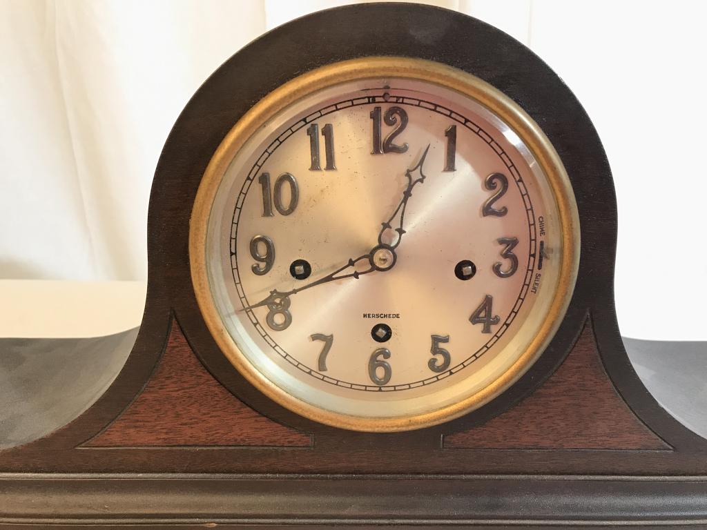 HERSCHEDE Wooden Mantel Clock: Clockface reads HERSCHEDE. Piece is brown toned and wooden. Measures approx 21 inches long 9 inches tall, 6 inches deep. mantlepiece decor, clock, collectible time piece 6.