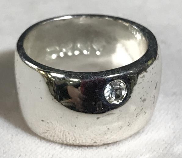 DKNY Silver Tnd Band Ring W Single Rhinestone: Silver tone metal band ring with single rhinestone detail. Marked for DKNY. Measures approx 4 in Ring size. Some tarnishing Of Metal, will need polishing. Vintage ring, rhinestone ring, Statement ring