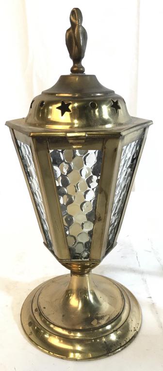 Gold Toned Candlestick Lamp: Lamp is gold toned and metal possibly brass. Piece has circular and star shaped pierced detail on lid. Base is circular. Top of piece has attached finial. Interior utilizes Candlestick Light, not elec