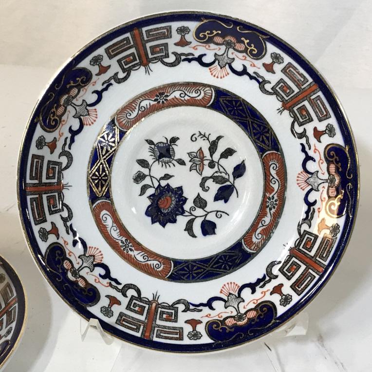 Set 13 Vintage Japanese Ironstone Tableware: 3 tea cups and 10 tea cup saucers. Dark blues, rust and gold color the Japanese angular patterns, lines designs and floral patterns. Some items have visible stamp marks, but somewhat illegible. Stamp